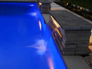 night lit pool with water fountains pouring into them